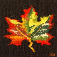 Tapestry of a maple leaf against a black-brown background