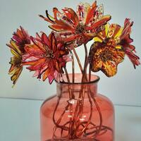 Kiln-formed fused glass flowers on unique copper stems, displayed in a recycled glass vase