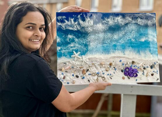 Resin, mixed-media artist showing the ocean wave art on a A2 canvas board