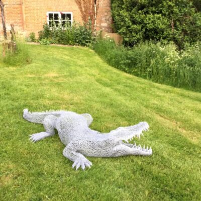 Lindsay Neale Waring - Sculptor: Crocodile was a commission by a previous customer.  He allowed me to have huge artistic freedom with this which really excited me. With the Tiger i started the work with the head but when i started the Croc project i already knew the challenges on a head with an open mouth so i started with the feet this time. For me the feet were integral to showing the tension in this form. He is made from chicken wire again and again i really only needed a pair of pliers and a hook. I prefer to keep the process as natural as possible in order to really connect to the process and material. He now resides in Oxford with a cockerel i made for this customer previously.